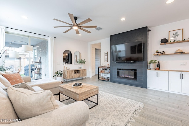 living area featuring recessed lighting, visible vents, a large fireplace, and ceiling fan