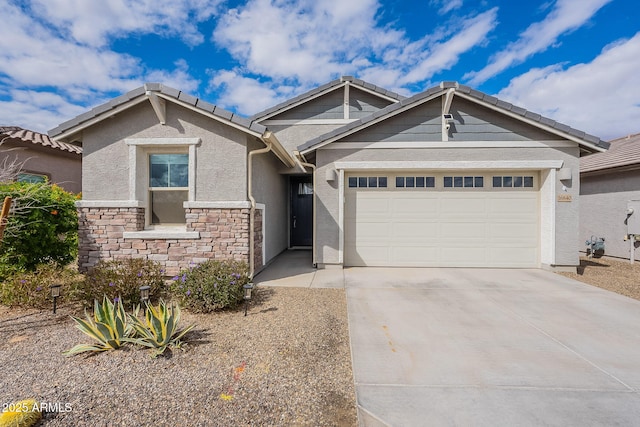 view of front facade featuring stone siding, stucco siding, an attached garage, and concrete driveway