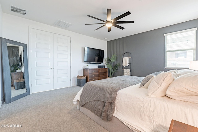 carpeted bedroom featuring a closet, visible vents, and ceiling fan