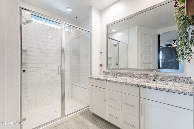 bathroom featuring double vanity, recessed lighting, a stall shower, and a sink