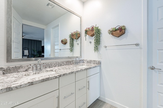 full bath featuring double vanity, wood finished floors, visible vents, and a sink