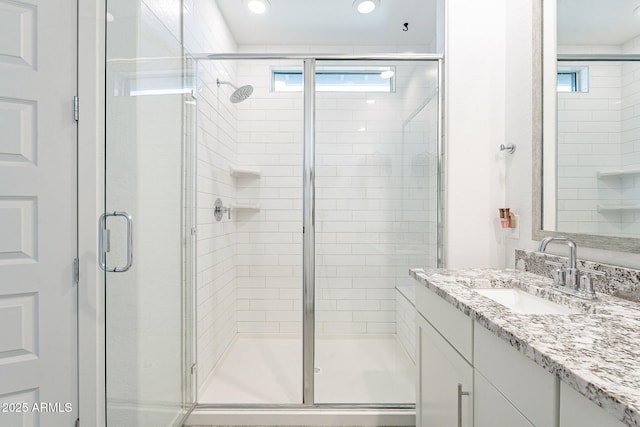 full bath with vanity and a shower stall