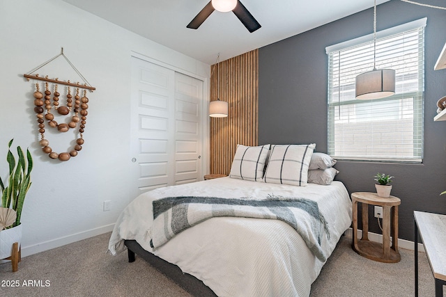 bedroom featuring a closet, baseboards, carpet, and ceiling fan