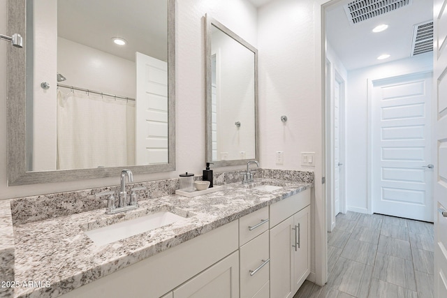 full bathroom featuring double vanity, visible vents, and a sink