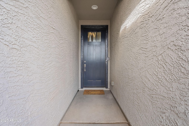 entrance to property featuring stucco siding