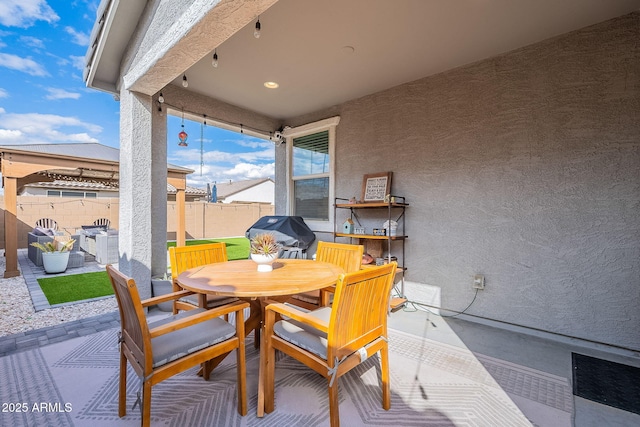 view of patio / terrace with outdoor dining space, fence, and a grill