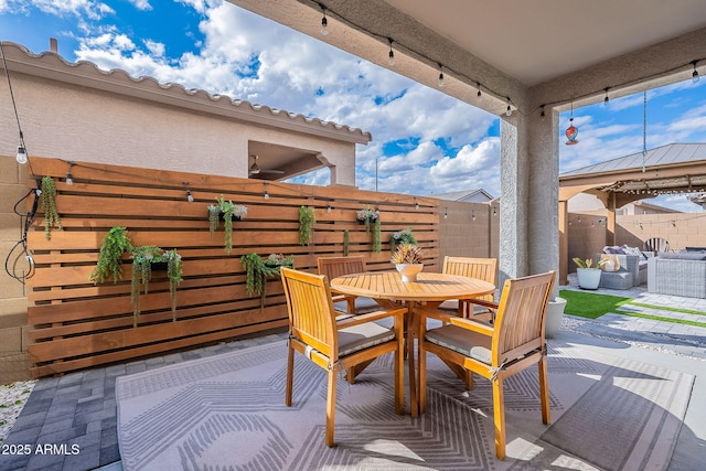 wooden terrace featuring outdoor dining area, a patio, and fence