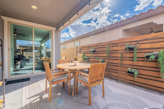 view of patio featuring outdoor dining space, grilling area, and fence