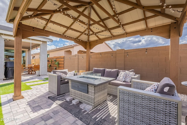 view of patio with a gazebo, an outdoor living space with a fire pit, and fence