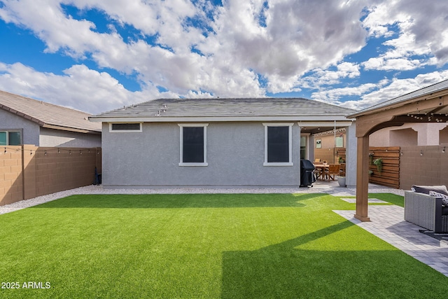 back of house with a patio, a fenced backyard, a lawn, and stucco siding