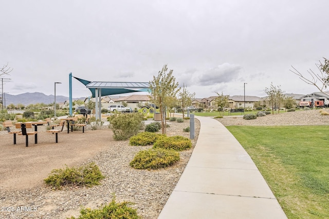 view of property's community featuring a mountain view, a yard, and a residential view