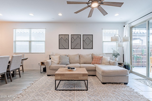 living area with recessed lighting, a ceiling fan, and baseboards