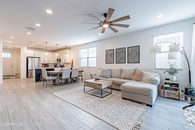 living area with recessed lighting, visible vents, and ceiling fan