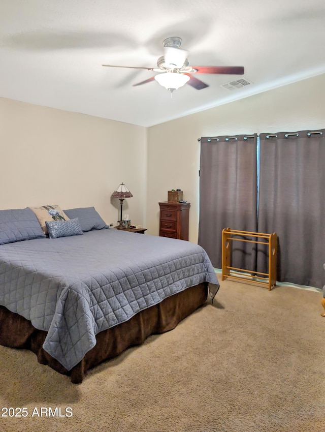 carpeted bedroom featuring a ceiling fan, visible vents, and ornamental molding