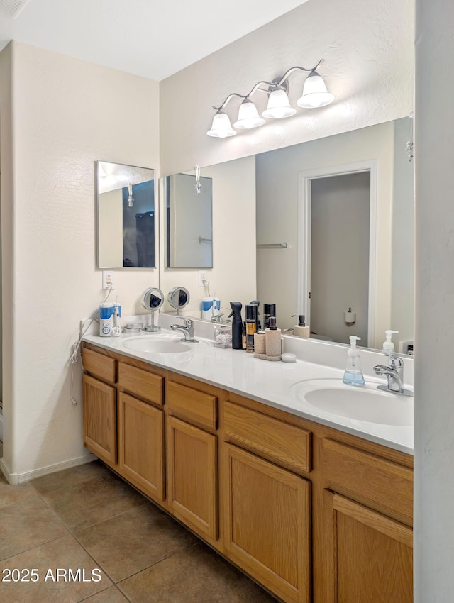 full bath with double vanity, a sink, and tile patterned floors