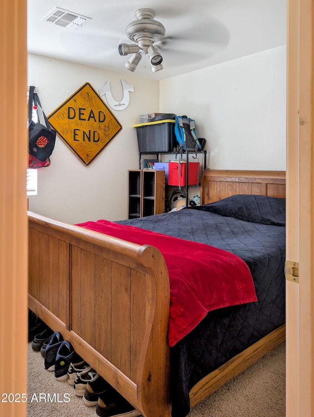 carpeted bedroom with visible vents and a ceiling fan