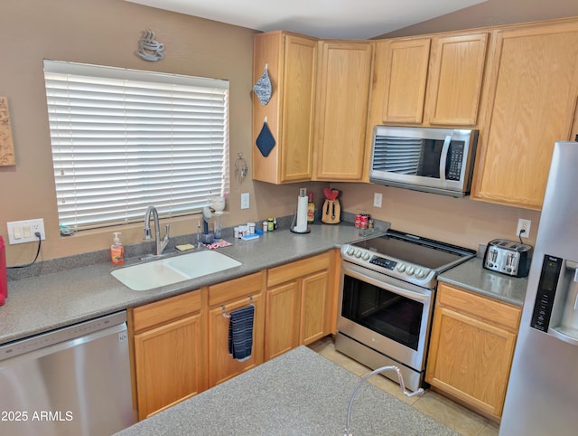 kitchen with light tile patterned floors, light brown cabinets, appliances with stainless steel finishes, and a sink