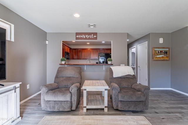 living room featuring light hardwood / wood-style flooring and sink