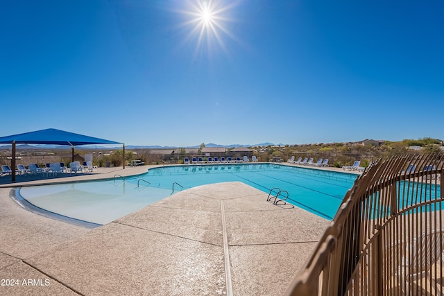 view of swimming pool with a mountain view and a patio area