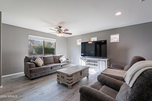 living room featuring light hardwood / wood-style flooring and ceiling fan