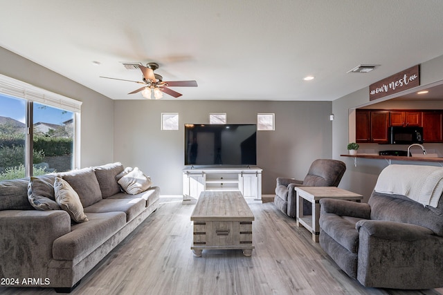 living room featuring ceiling fan and light wood-type flooring