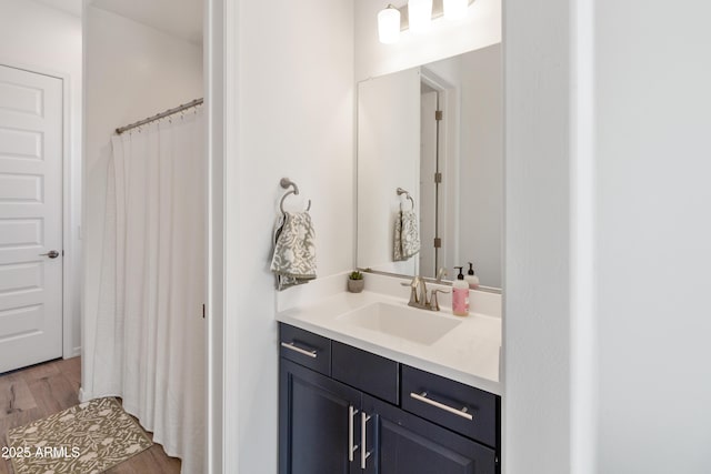 bathroom featuring hardwood / wood-style flooring, vanity, and curtained shower