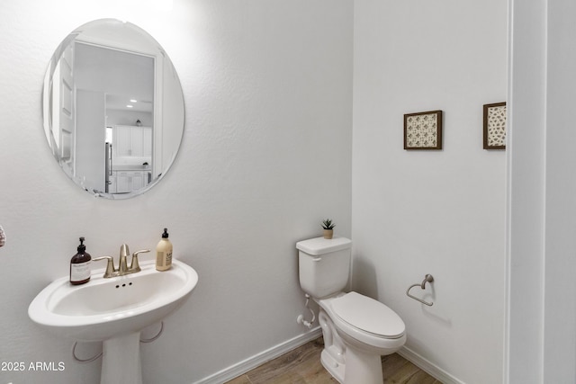 bathroom with hardwood / wood-style flooring and toilet