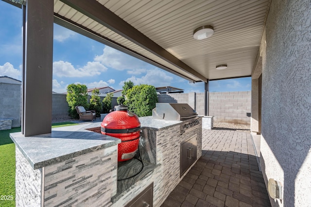 view of patio / terrace featuring exterior kitchen and a grill