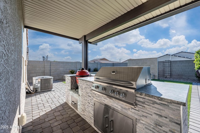 view of patio featuring an outdoor kitchen, area for grilling, and central air condition unit