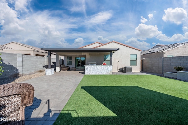 rear view of house with central AC unit, a patio area, and a yard