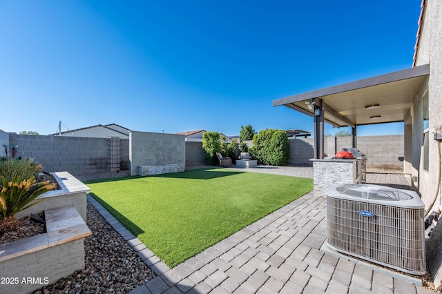 view of yard featuring central air condition unit and a patio area