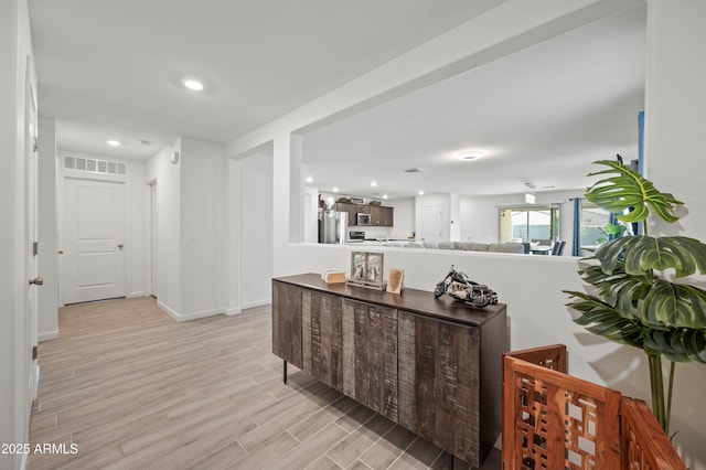 corridor with light hardwood / wood-style floors