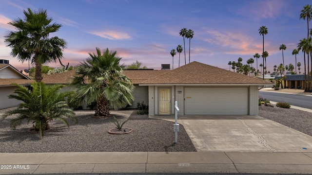 9917 W Cameo Dr, Sun City, AZ 85351 - view of front of property with a garage, brick siding, concrete driveway, and roof with shingles