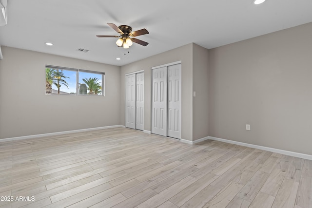 9917 W Cameo Dr, Sun City, AZ 85351 - unfurnished bedroom with two closets, light wood-type flooring, recessed lighting, baseboards, and a ceiling fan