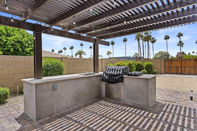 9917 W Cameo Dr, Sun City, AZ 85351 - view of patio featuring a fenced backyard, an outdoor kitchen, and area for grilling