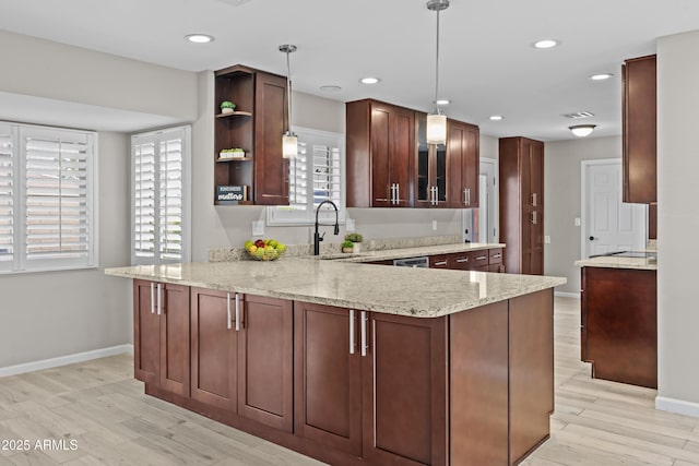 9917 W Cameo Dr, Sun City, AZ 85351 - kitchen featuring a sink, a peninsula, baseboards, light stone counters, and light wood-style floors