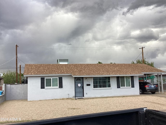 single story home with a shingled roof, brick siding, and fence