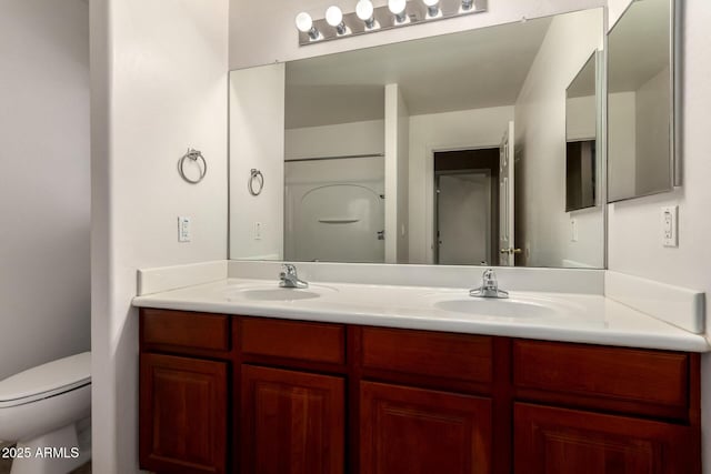 bathroom featuring a sink, toilet, and double vanity