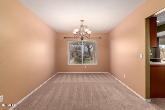 empty room with light carpet, a notable chandelier, and baseboards