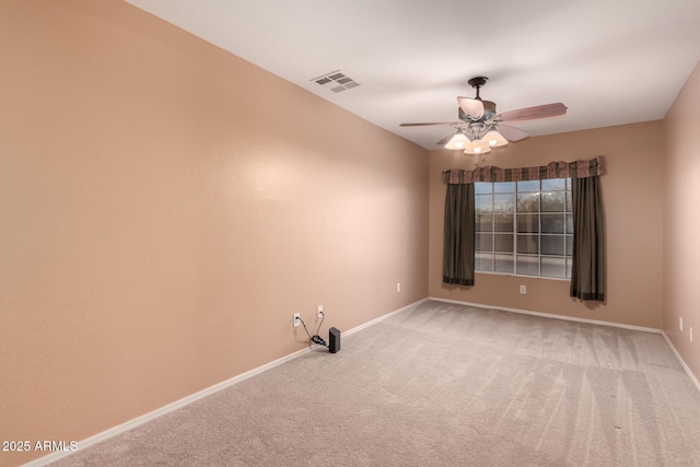 carpeted empty room featuring baseboards, visible vents, and ceiling fan