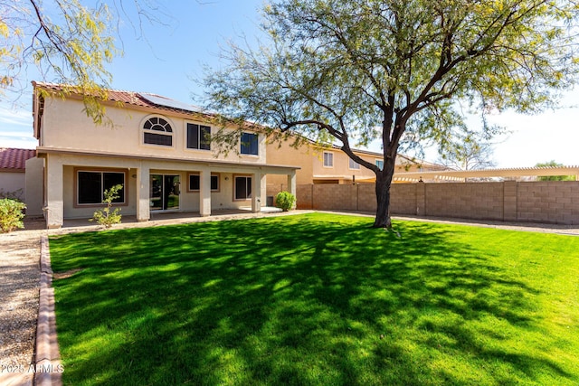 back of property with a fenced backyard, a lawn, a patio, and stucco siding