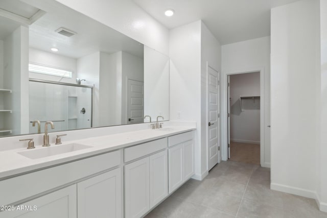 bathroom featuring vanity, a shower with shower door, and tile patterned flooring