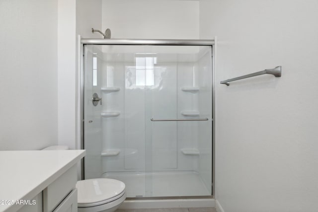 bathroom featuring vanity, toilet, and an enclosed shower