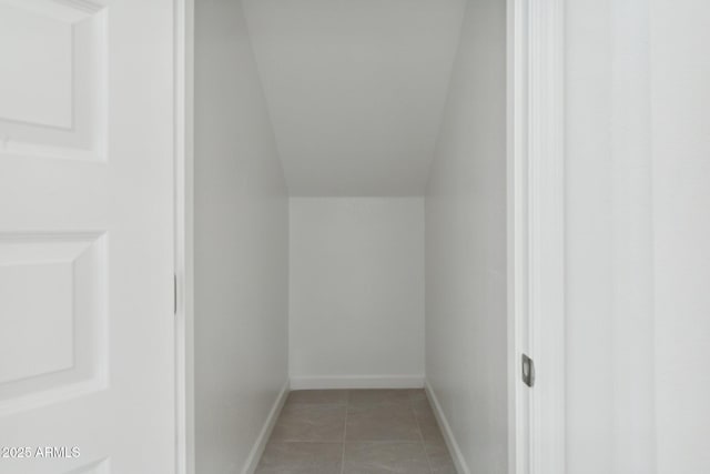 interior space featuring vaulted ceiling and tile patterned flooring