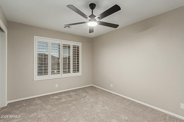 empty room with carpet, visible vents, ceiling fan, and baseboards