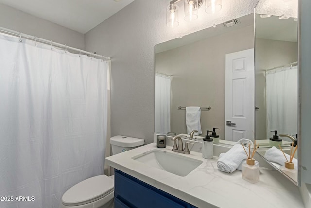 full bath with visible vents, a textured wall, vanity, and toilet