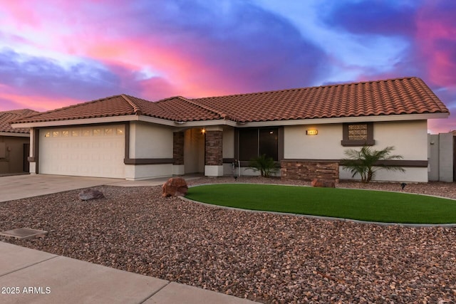 view of front of house featuring an attached garage, stone siding, concrete driveway, and stucco siding