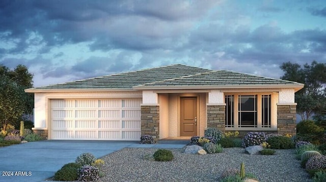 prairie-style house featuring an attached garage, stone siding, concrete driveway, and stucco siding