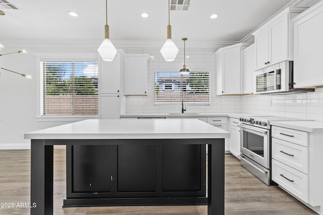 18998 E Lark Dr, Queen Creek, AZ 85142 - kitchen with appliances with stainless steel finishes, a sink, a center island, light countertops, and crown molding