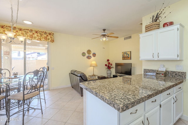 kitchen featuring visible vents, a peninsula, white cabinets, light tile patterned floors, and ceiling fan